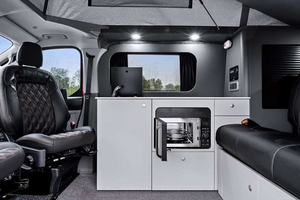 Bespoke Leisure Explore interior — premium Type-Approved conversion with pop-top roof, kitchen unit, and swivel cab seat
