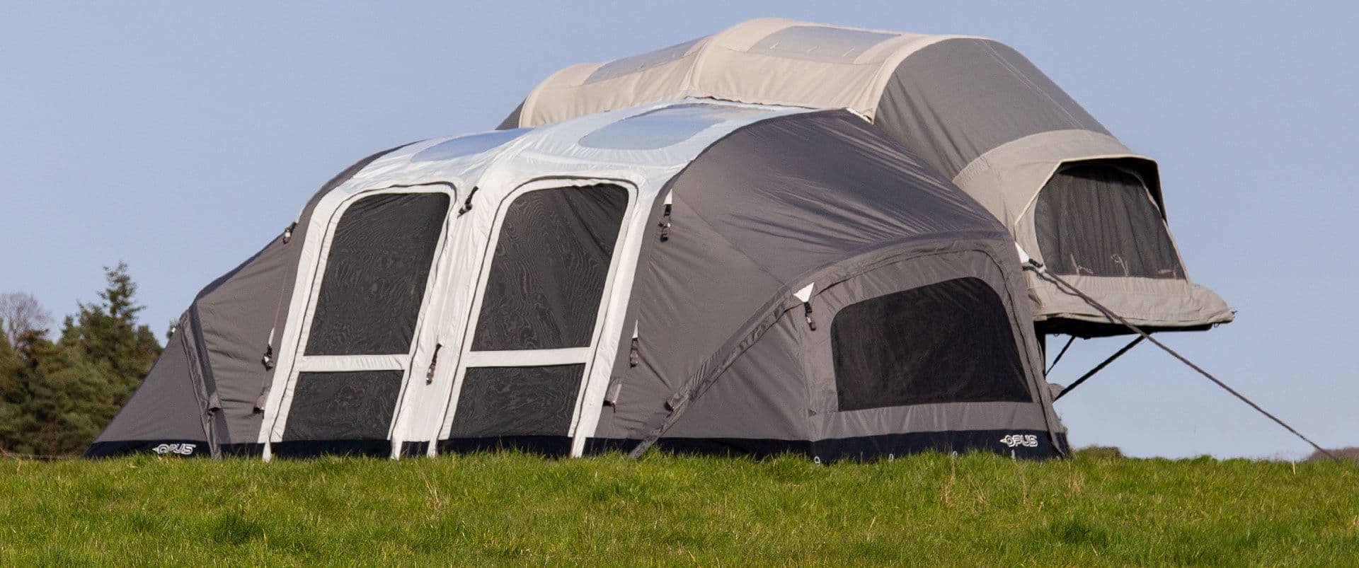 Opus folding camper erected at campsite with awning