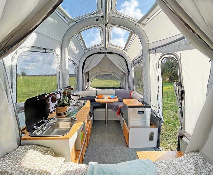 Interior of an Opus folding camper showing kitchen and seating area